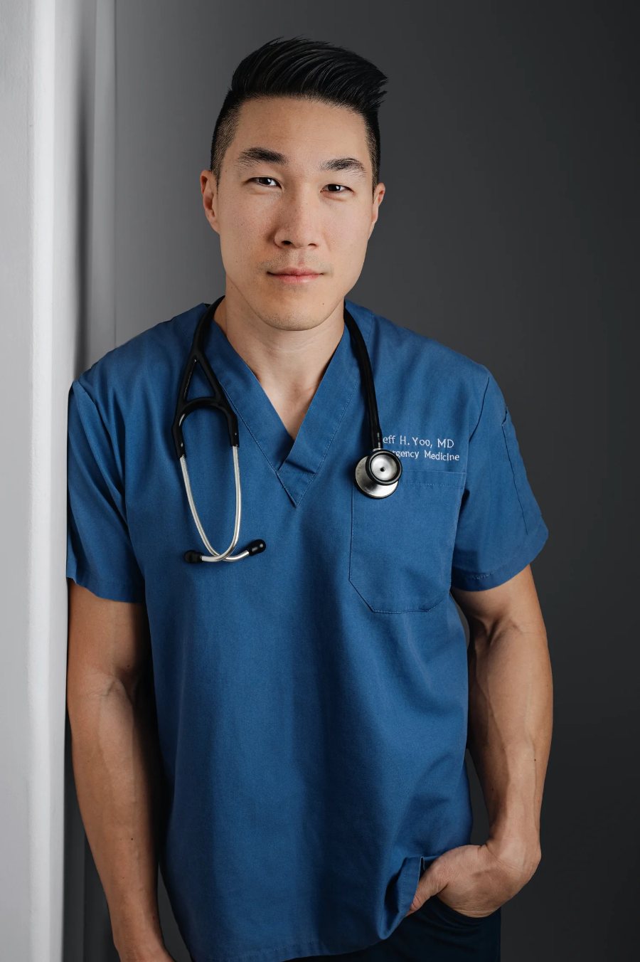 Dr. Jeff Yoo in navy scrubs with a stethoscope